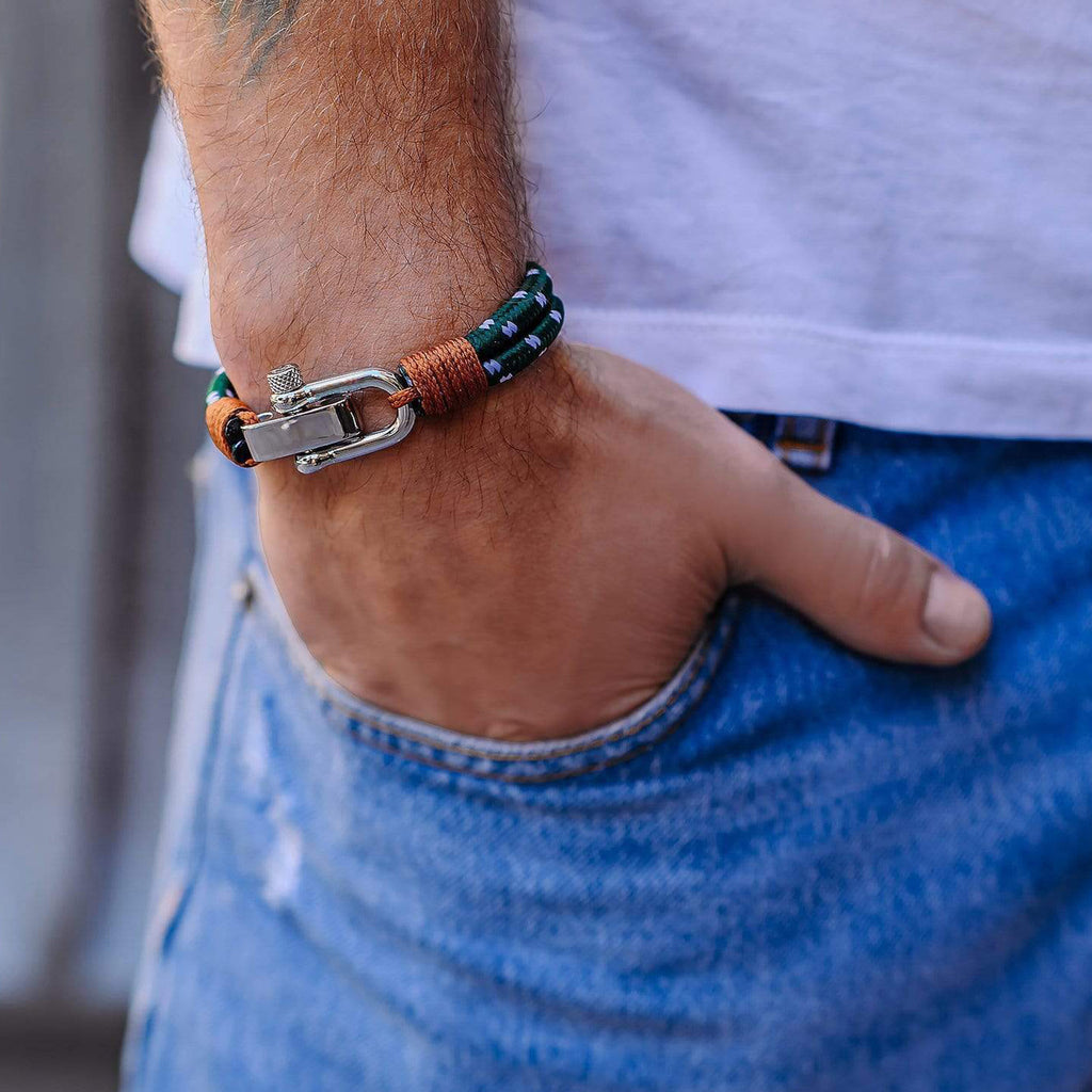 Bracelet homme bleu vert beige en cuir tressé avec mousqueton acier inoxydable porté au poignet.