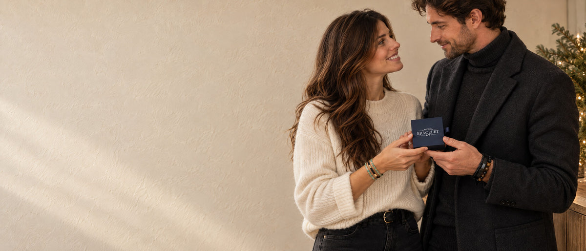 Couple échangeant le coffret signature La Boutique du Bracelet dans une ambiance de Noël minimaliste