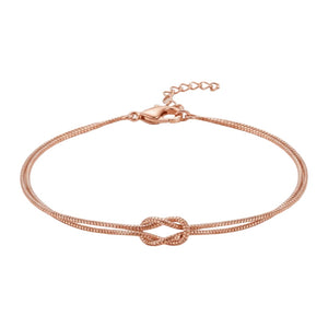 Bracelet en acier inoxydable rose avec nœud central et chaîne fine réglable.