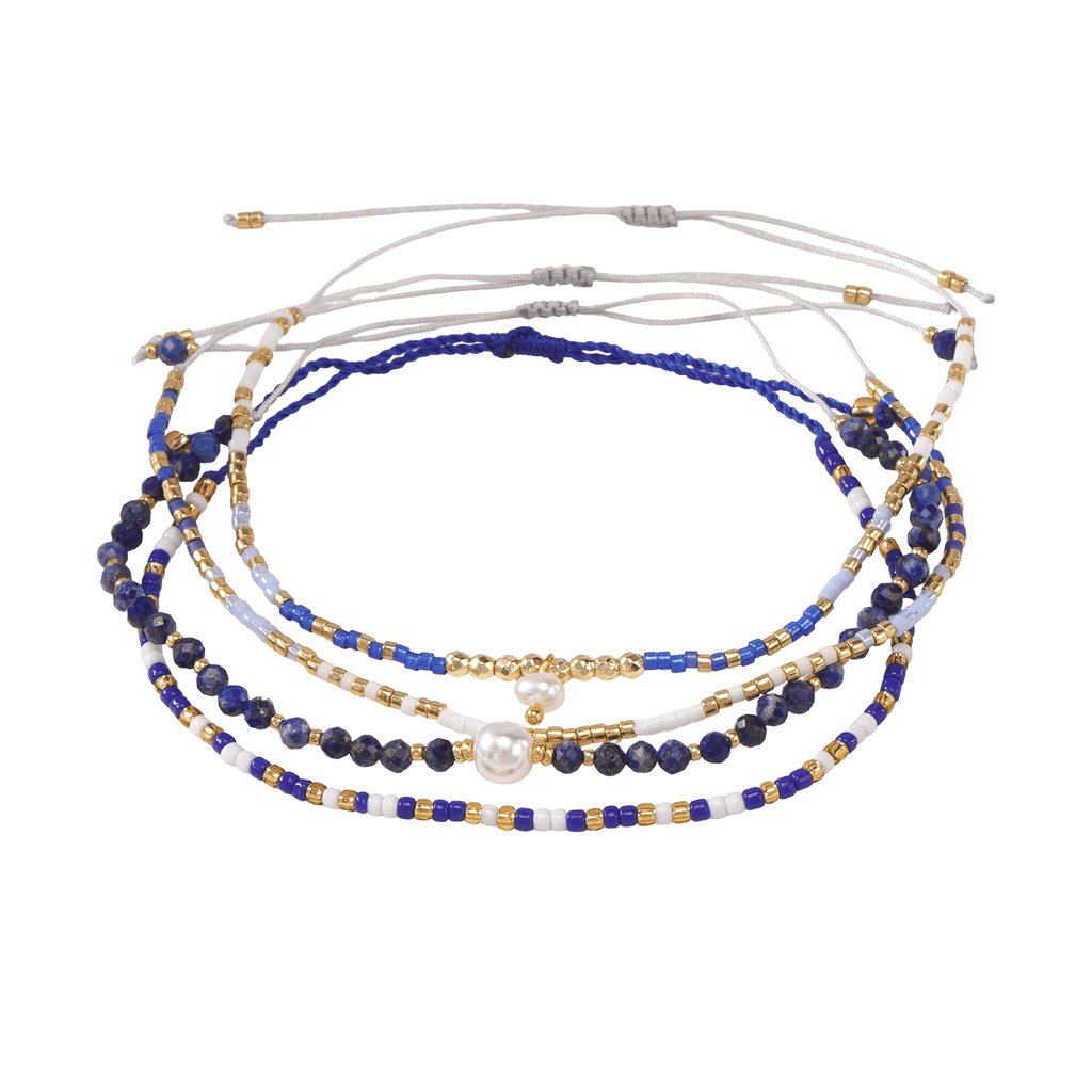Set de bracelets fins en perles bleues lapis lazuli, dorées et blanches avec cordons ajustables blanc et bleu.