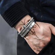 Trio de bracelets en acier inoxydable argenté avec détails couronne et chaînes pour homme.