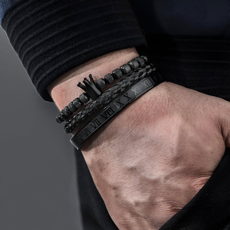 Trio de bracelets noirs en acier inoxydable avec motif couronne et détails gravés, style masculin élégant.