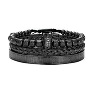 Trio de bracelets homme noirs en acier inoxydable, un tressé, un à billes, un avec détails chiffres romains et couronne.