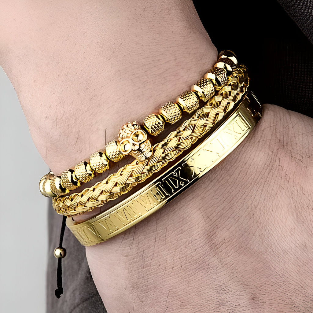 Trio de bracelets homme en acier inoxydable or, avec tête de mort et détails texturés.