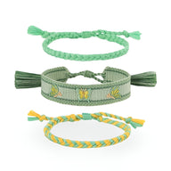 Trio de bracelets en coton tissé vert et jaune avec motifs papillons et tressés manches nouées.