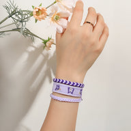 Trio de bracelets en coton violet et blanc tissé avec motif papillons, style Tisara, porté au poignet féminin.