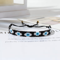 Trio de bracelets noirs en perles japonaises arrondies avec motif œil bleu et blanc, fermoir coulissant.