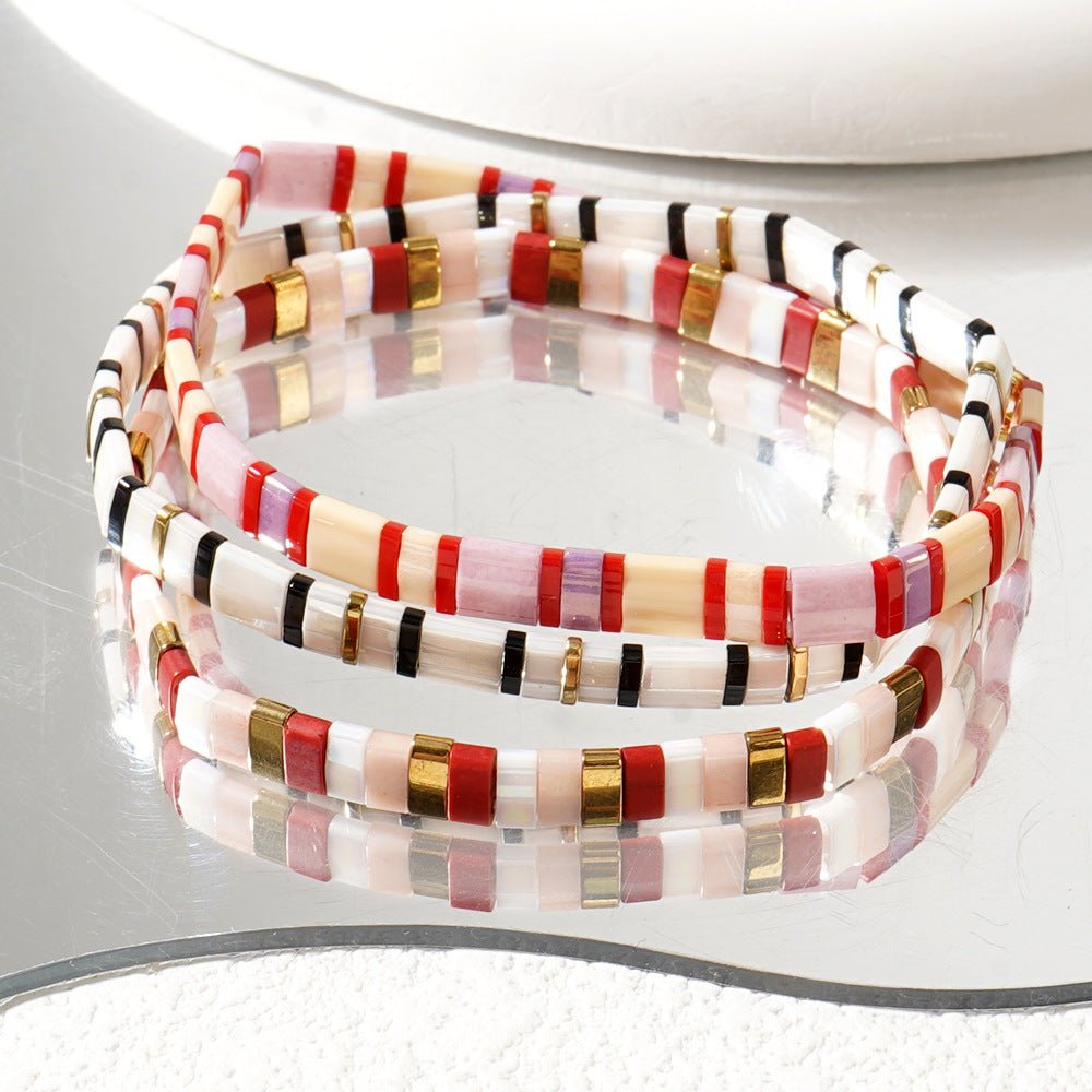 Trio de bracelets fins en perles japonaises multicolores avec accents dorés, style bohème élégant.