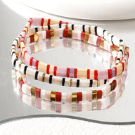 Trio de bracelets fins en perles japonaises multicolores avec accents dorés, style bohème élégant.
