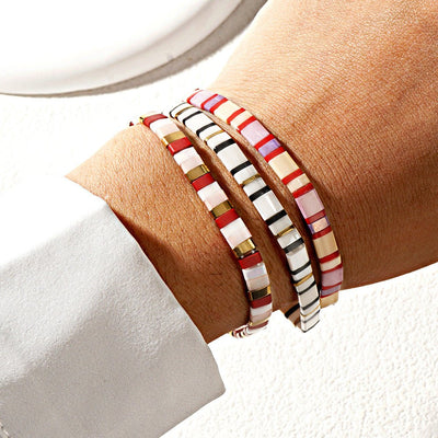 Trio de bracelets en perles japonaises multicolores sur fil beige, style moderne et épuré.