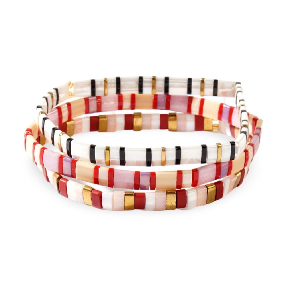 Trio de bracelets en perles japonaises multicolores avec motifs rouges, blancs, noirs et dorés.