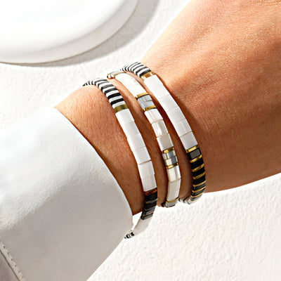 Trio de bracelets en perles blanches et noires, style minimaliste et élégant, pour femme.
