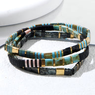 Trio de bracelets en perles multicolores japonaises avec accents dorés et design géométrique.