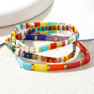 Trio de bracelets en perles multicolores Japonaises avec motifs géométriques et éclats dorés.