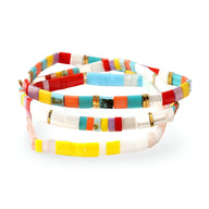 Trio de bracelets en perles multicolores japonais, tons jaunes, rouges, turquoise et blancs, détails dorés.