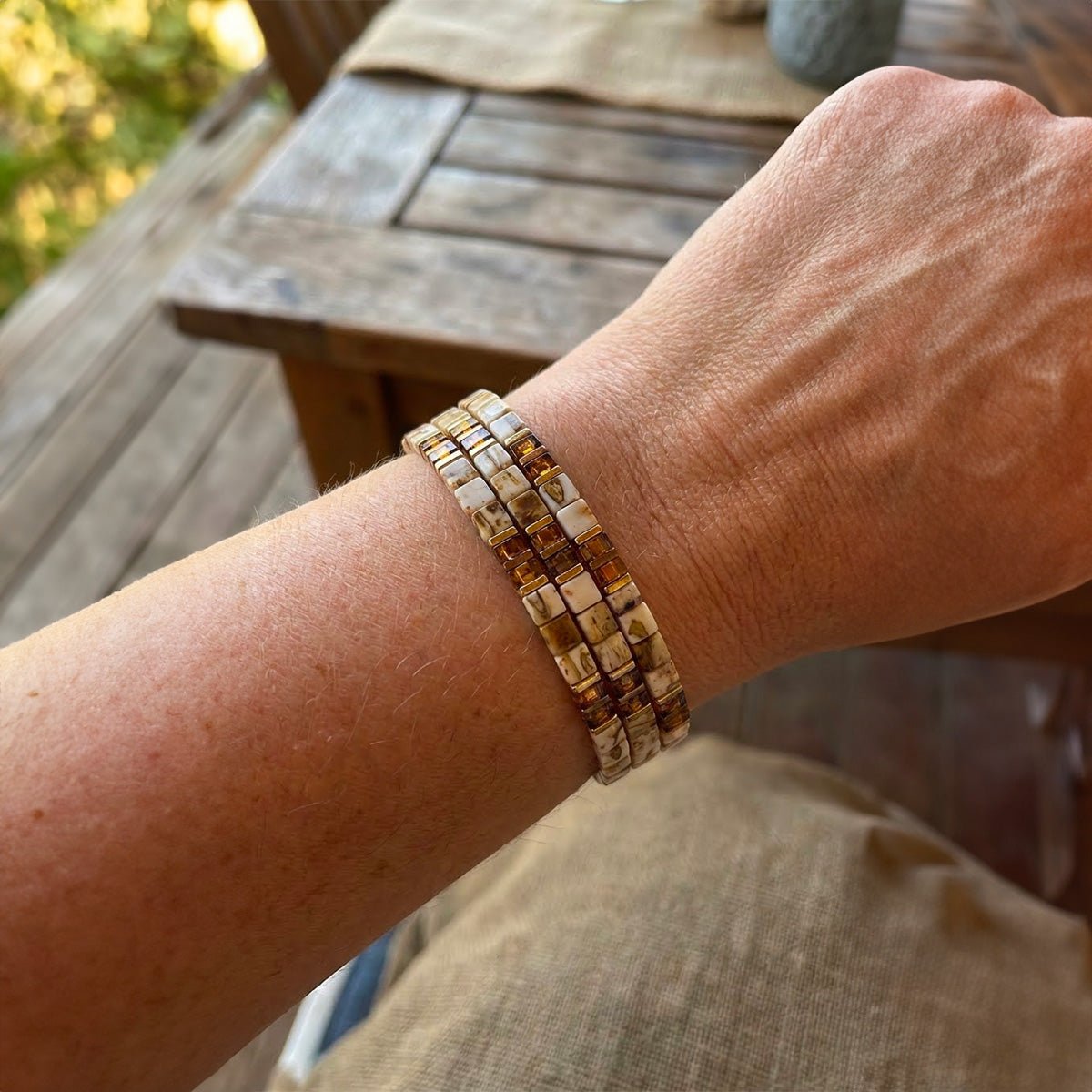 Trio de bracelets élastiques en perles japonaises aux reflets caramel, motifs nacrés et design léopard subtil.