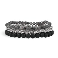 Trio de bracelets pour homme avec pierres naturelles volcaniques noires et perles grises en acier maillé argenté.