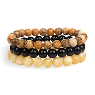 Trio de bracelets en pierres naturelles beige, noir, et marron avec perles rondes lisses.