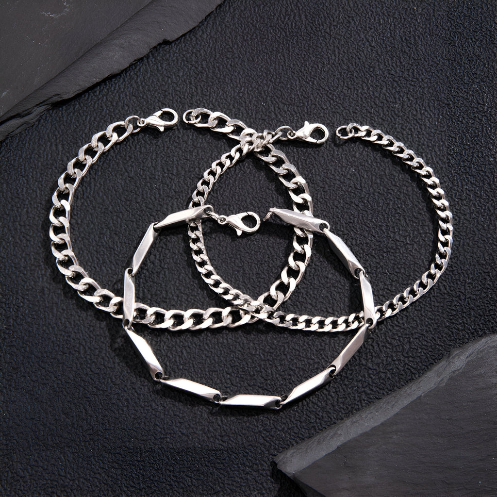 Trio de bracelets homme en titane argenté, maillons larges et finement texturés, fermoirs mousqueton.