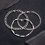 Trio de bracelets homme en titane argenté, maillons larges et finement texturés, fermoirs mousqueton.