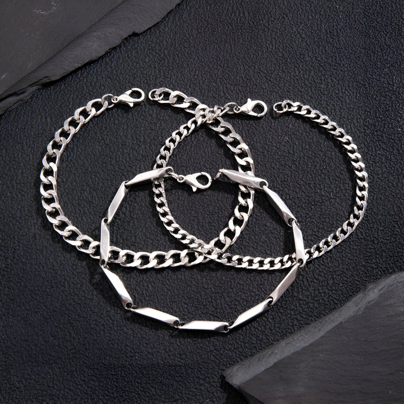 Trio de bracelets homme en titane argenté, maillons larges et finement texturés, fermoirs mousqueton.