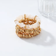 Trio de bracelets anneaux dorés et pierres blanches brillantes, style élégant et texturé.