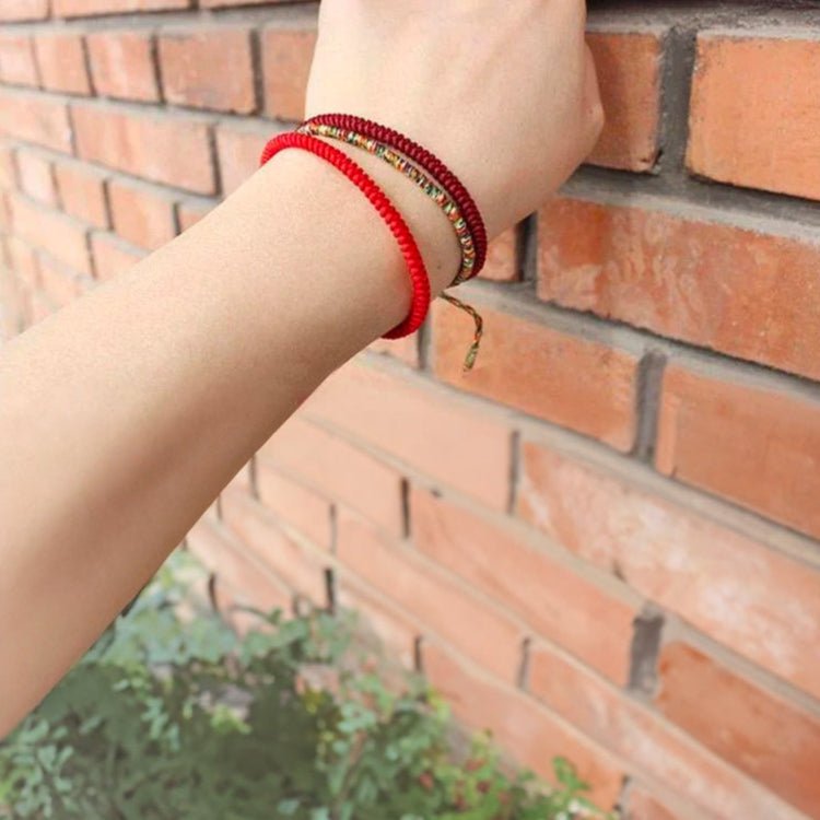 Trio de bracelets tibétains rouges en fil ciré avec perles dorées, style minimaliste et élégant.