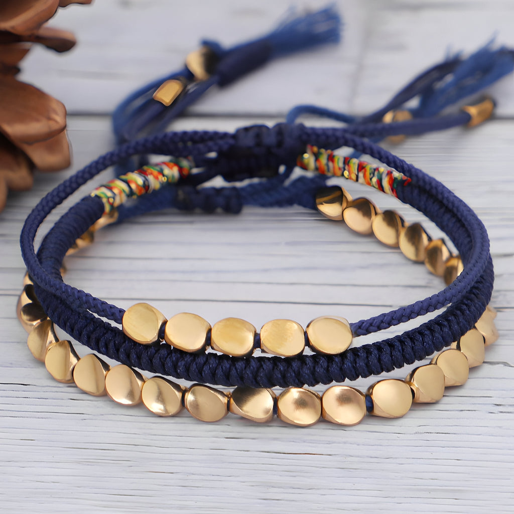 Trio de bracelets tibétains en corde bleue avec perles en cuivre doré style porte-bonheur.
