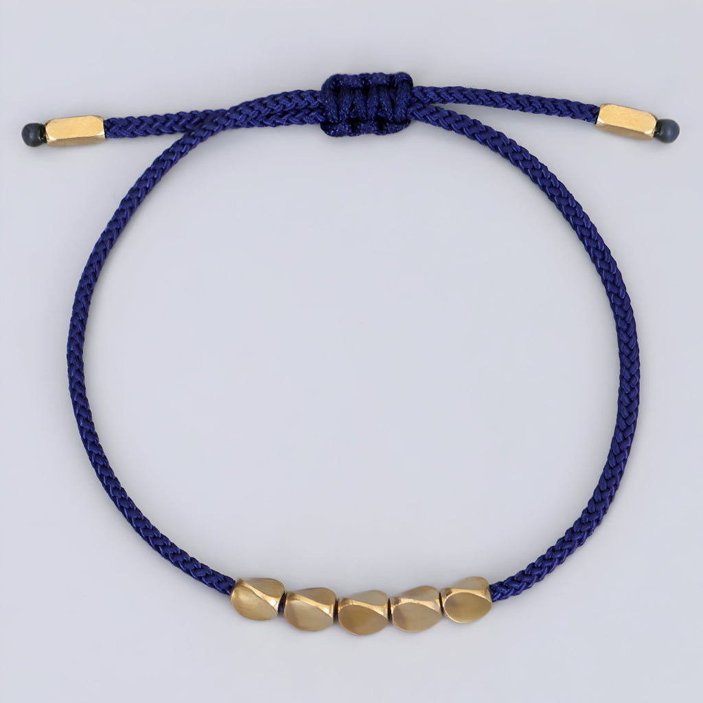 Bracelet tibétain bleu en corde avec cinq perles en cuivre doré, modèle Dolma pour femme.