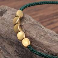 Bracelet vert en corde avec cinq perles en cuivre doré lisse, style tibétain porte-bonheur.
