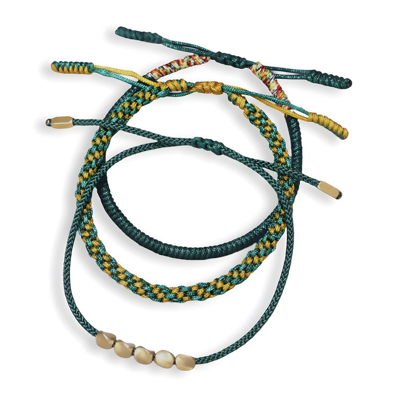 Trio de bracelets tibétains en corde verte et cuivre, avec perles et tressages variés.