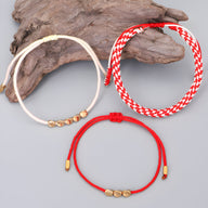 Trio de bracelets tibétains en corde avec perles de cuivre doré, couleurs rouge, blanc et écru.