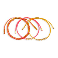 Trio de bracelets tibétains en corde rouge, rose et jaune avec perles de cuivre.