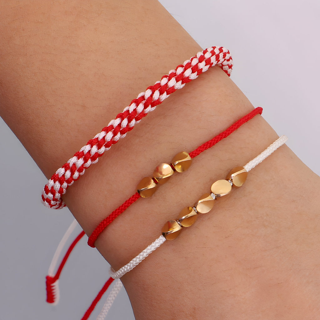 Trio de bracelets tibétains en corde rouge, blanc et cuivre à motifs cœurs et ronds.