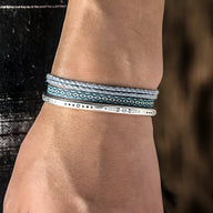 Trio de bracelets tibétains pour homme en coton bleu et gris avec fine bande en argent gravée.