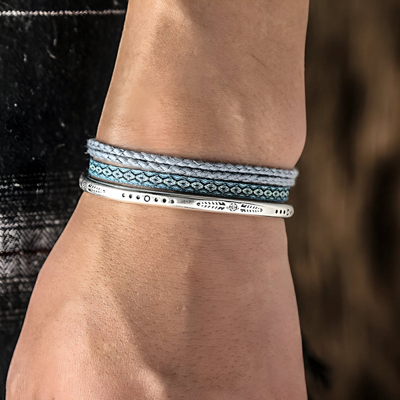 Trio de bracelets tibétains pour homme en coton bleu et gris avec fine bande en argent gravée.