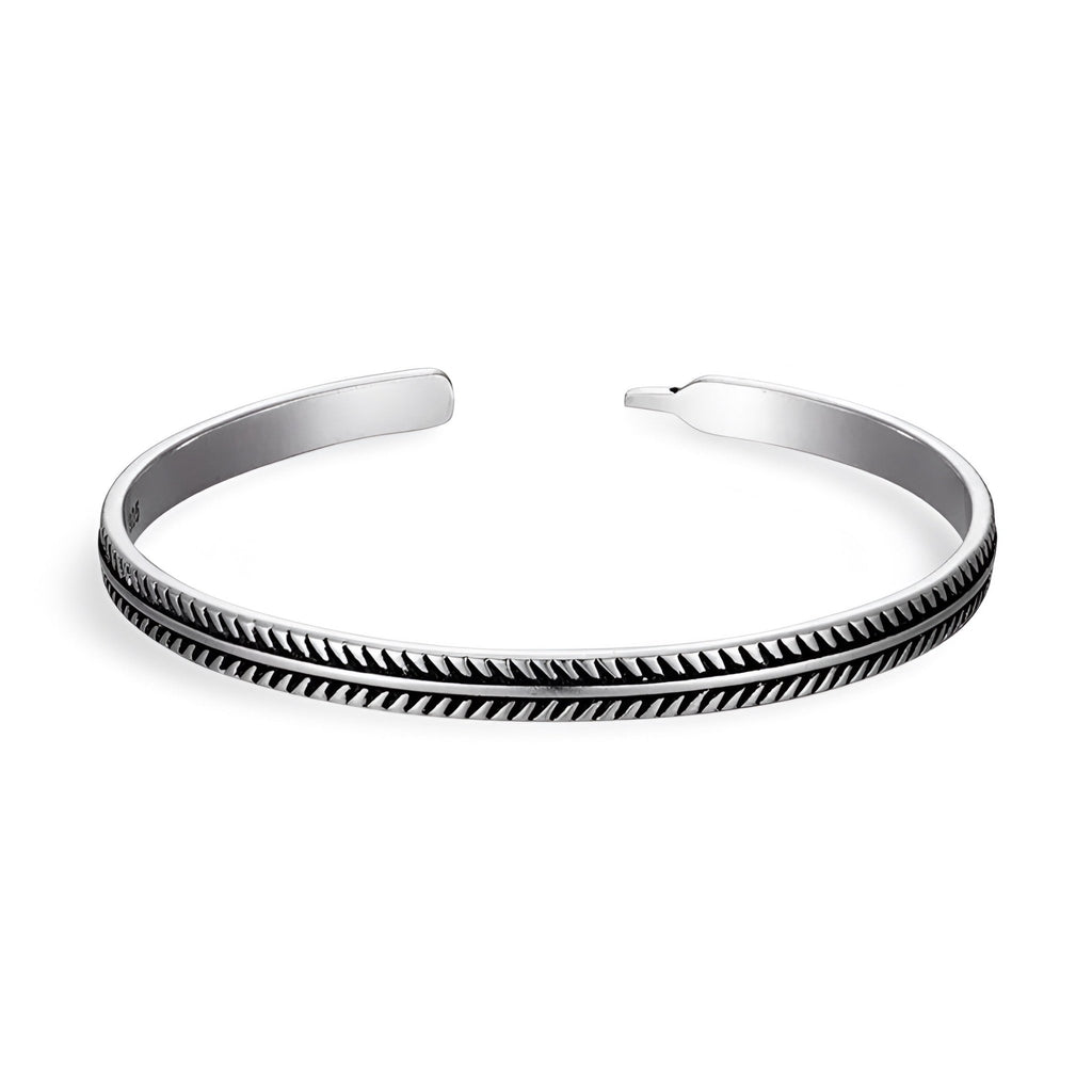 Bracelet ouvert en cuivre argenté avec motif chevrons noirs gravés, style tibétain élégant.