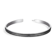 Bracelet ouvert en cuivre argenté avec motif chevrons noirs gravés, style tibétain élégant.