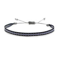 Bracelet tibétain bleu et noir en coton tressé avec fermoir coulissant gris.