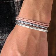 Trio de bracelets tibétains rose en coton avec un bracelet fin en argent gravé pour homme.