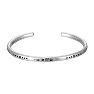 Bracelet jonc homme en argent avec motifs gravés et points noirs, finition polie.