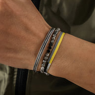 Trio de bracelets homme en jaspe gris, argent brossé, et corde jaune vif avec détails argentés.