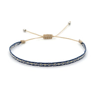 Bracelet tibétain tressé bleu avec cordon beige et fermoir coulissant en argent.