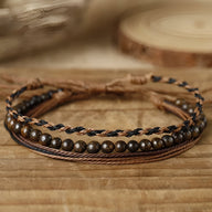 Trio de bracelets homme en pierres naturelles œil de tigre et fils cirés marron et noir enroulés.