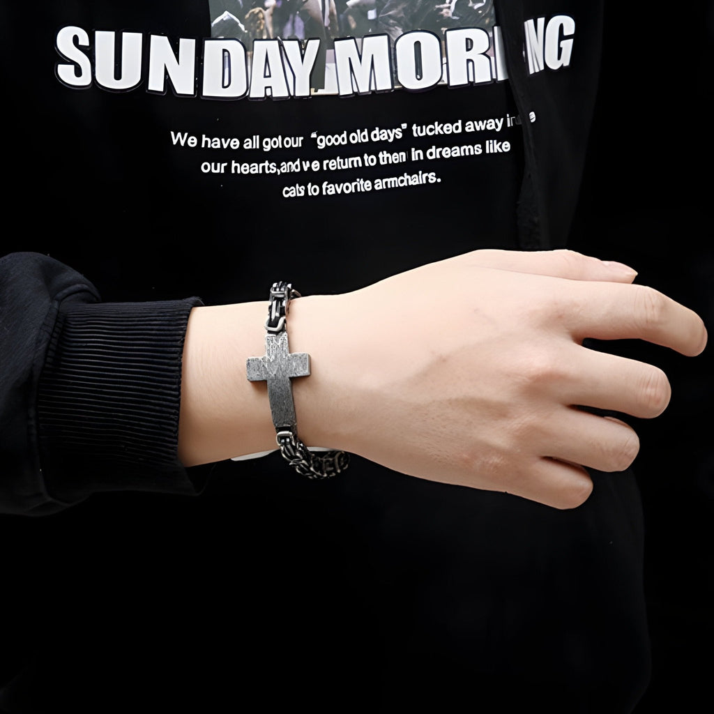 Bracelet homme en acier inoxydable noir avec motif croix centrale et maillons larges.