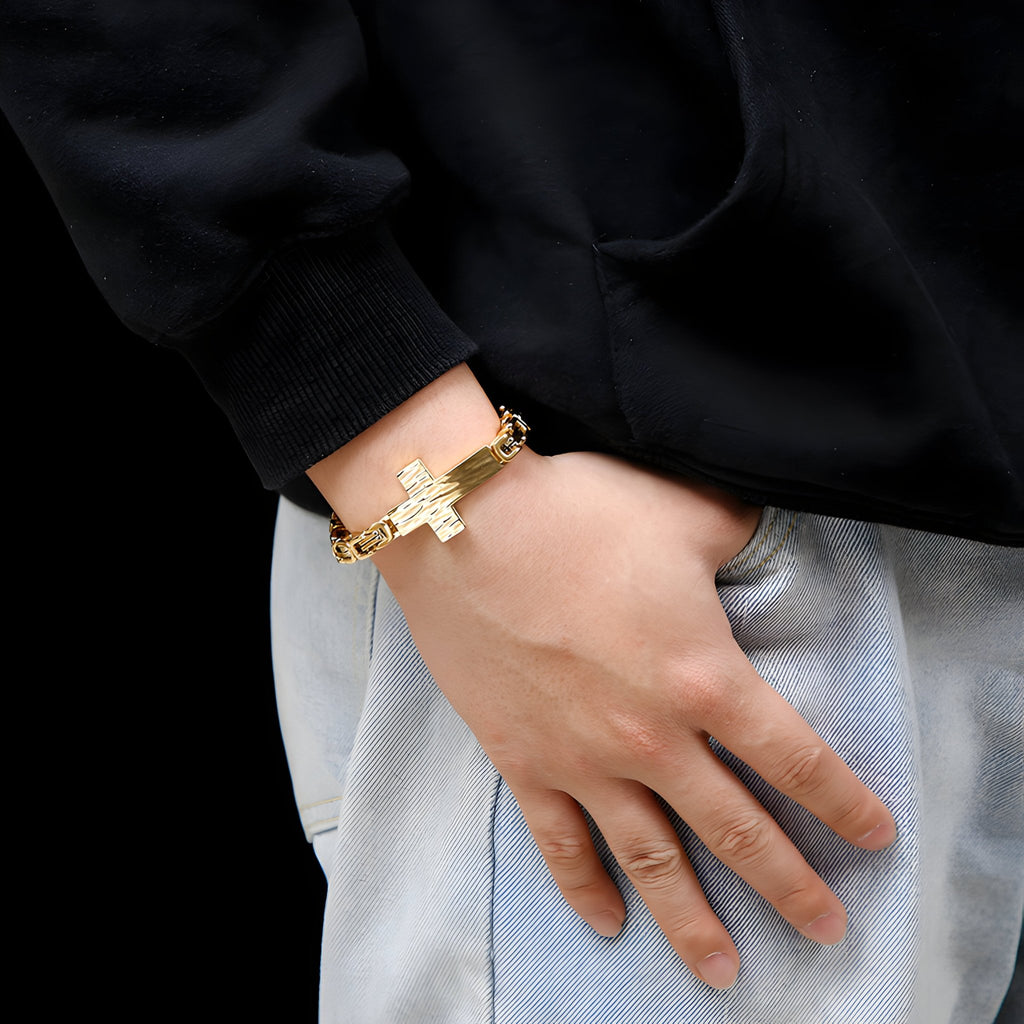 Bracelet homme en acier inoxydable doré avec motif croix central et maillons robustes.