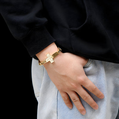 Bracelet homme en acier inoxydable doré avec motif croix central et maillons robustes.