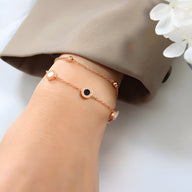 Bracelet ajustable en titane or rosé avec petits disques colorés et chaîne fine délicate.