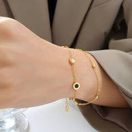 Bracelet ajustable doré en titane avec petits motifs colorés ronds et chaîne fine délicate.