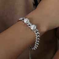 Bracelet en titane argenté avec chaînette épaisse et perles lisses sur le poignet.